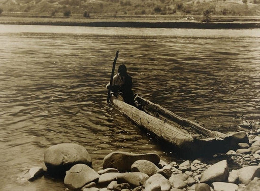 Edward Curtis - A Nez Perce man maneuvers a canoe, 1910 - FineArt Vendor